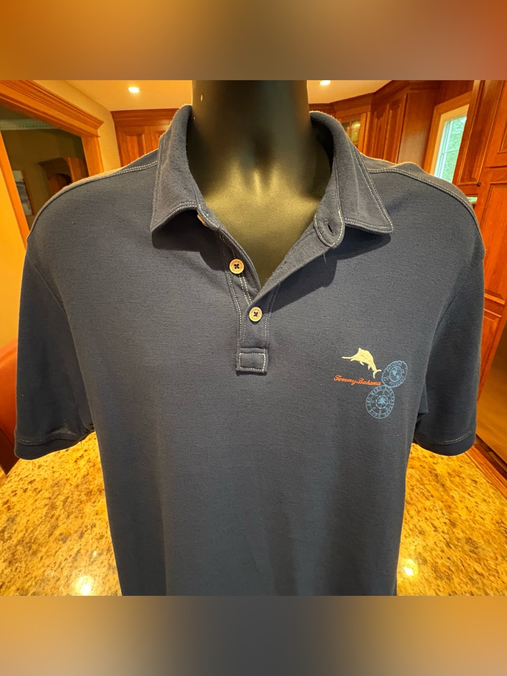 Tommy Bahama men’s beach polo. Sharp navy w/iconic logo on front, print on back.